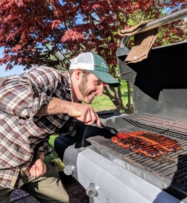 My friend's husband at the grill focusing on his seitan ribs